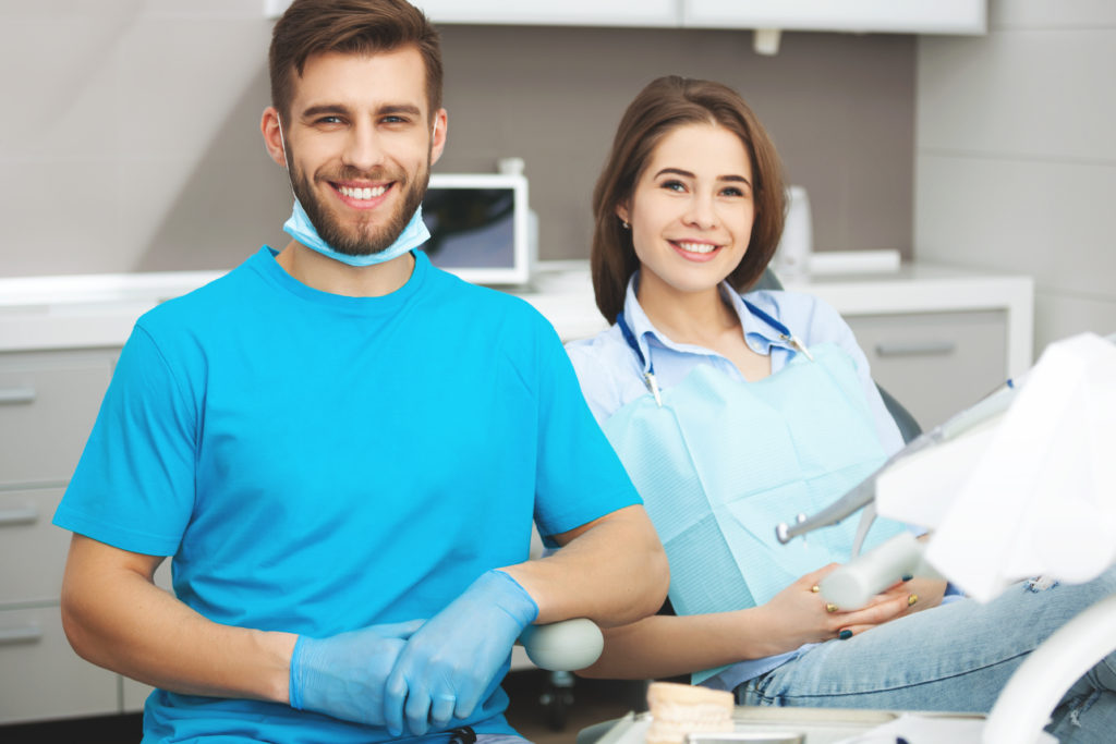 Portrait of a male dentist and happy patient